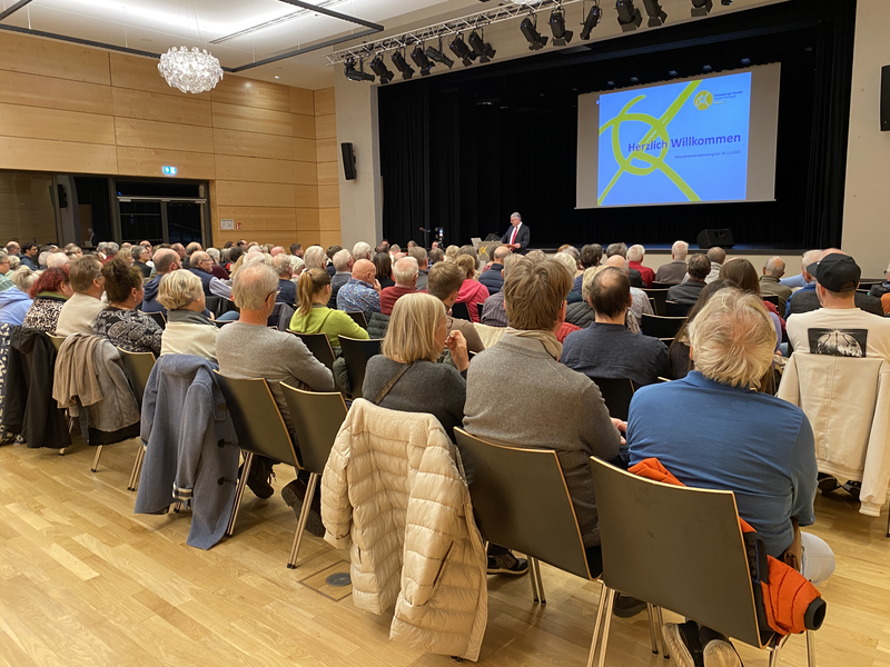 Viele Menschen sitzen in Stuhlreihen bei der Einwohnerversammlung 2025