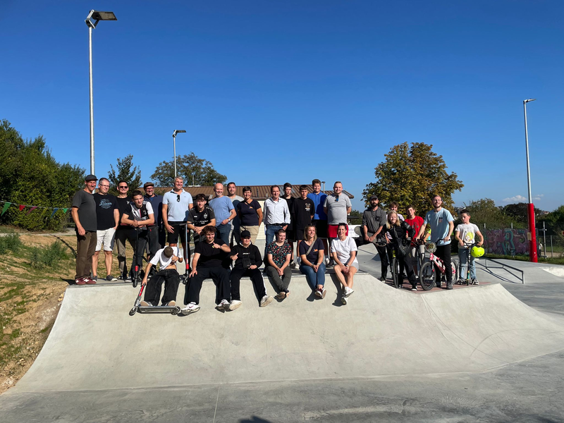 Jugendliche an einer Skaterbahn bei blauem Himmel.