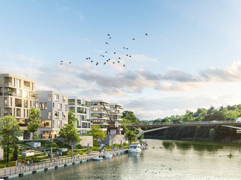 Eine Brücke und darunter ein Fluss. Links des Flusses stehen Gebäude. Am blauen Himmel fliegen bei Sonnenschein einige Vögel.