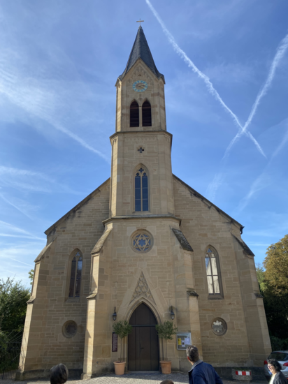 Eine Kirche bei strahlendem Sonnenschein und blauem Himmel.