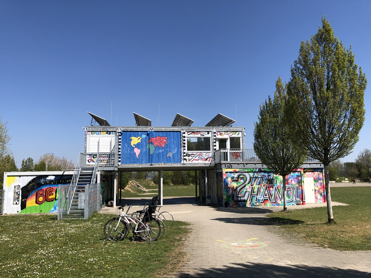 Aufeinandergestapelte Container am Eingang des Jugendgelände Pattonvilles.