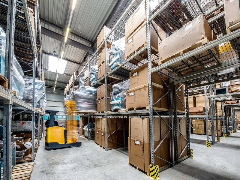 Gabelstapler, der in einer Lagerhalle Palletten transportiert.