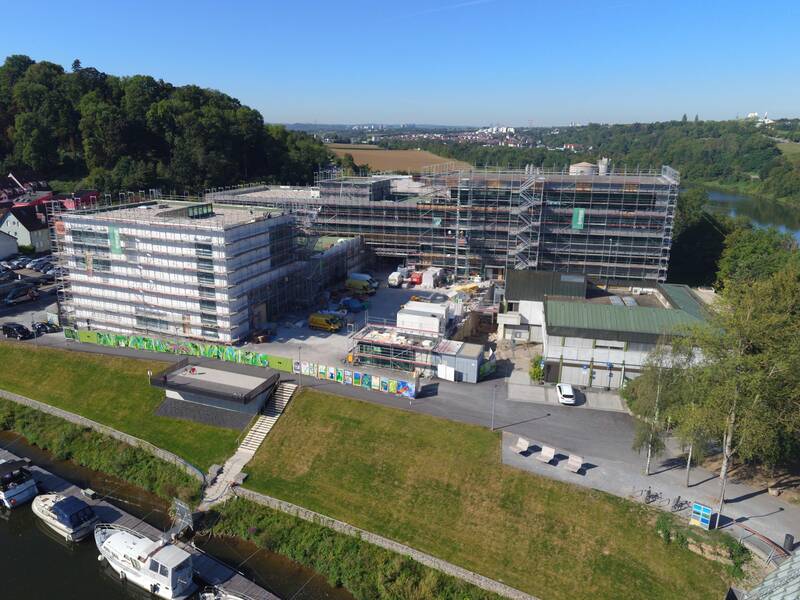 Ein großes Gebäude, welches sich im Bau beefindet und komplett eingerüstet ist.