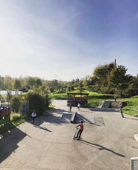 Kinder in einem Skatepark mit City-Rollern.