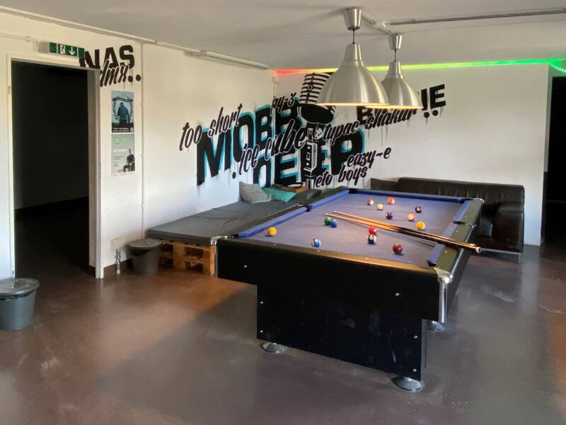 Jugendraum mit Dartscheibe und Billardtisch.