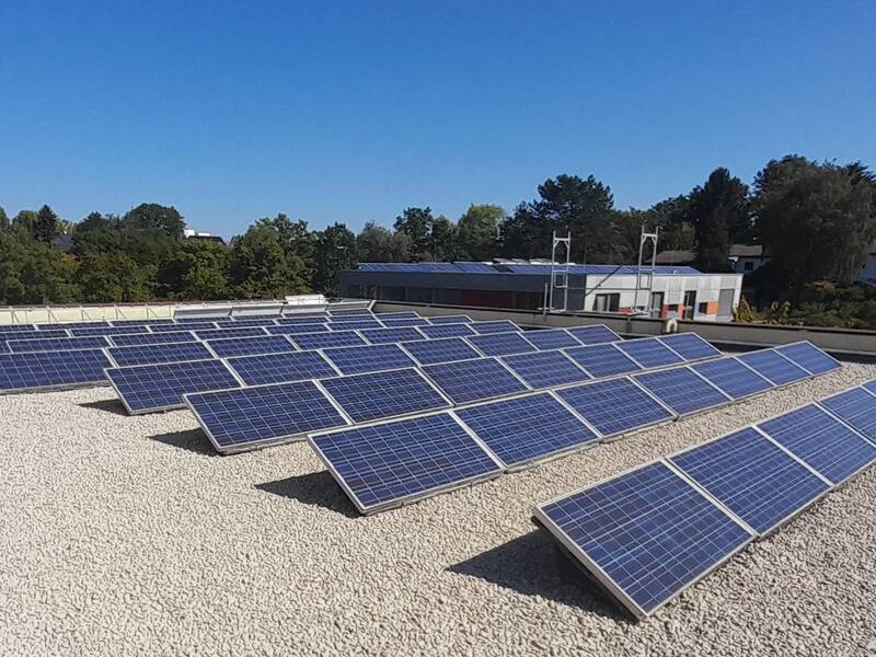 Photovoltaikanlage im Vordergrund. Himmel mit Wolken darüber.