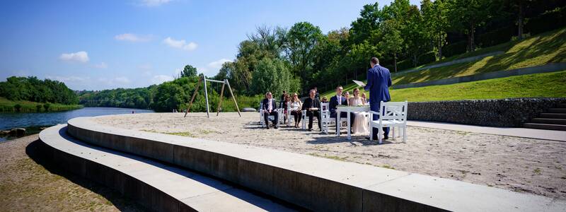 Neckarstrand mit festlich gekleideten Menschen.