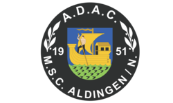 Das Bild zeigt ein Wappen mit einem gelben Segelschiff und einem Ruderer in der Mitte, umgeben von einem schwarzen Ring mit der Aufschrift "A.D.A.C. M.S.C. Aldingen" und den Jahreszahlen 1951.